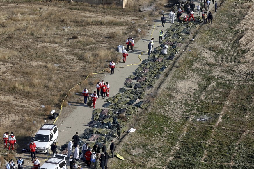 Bodies of the victims of a Ukrainian plane crash are collected by rescue team at the scene of the crash in Shahedshahr, southwest of the capital Tehran, Iran, Wednesday, Jan. 8, 2020. A Ukrainian pass ...