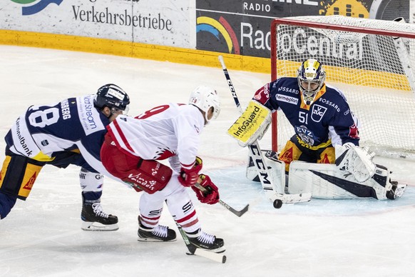 Zugs Carl Klingberg, Lausannes Cody Almond und Zugs Torhueter Luca Hollenstein, von links, beim Eishockey Meisterschaftsspiel der National League zwischen dem EV Zug und dem Lausanne HC, am Dienstag,  ...