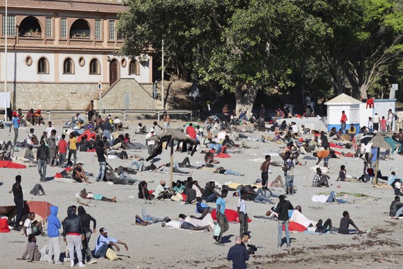epa13149565 Young migrants who arrived in Ceuta a few days earlier stand on Trampolin Beach in Ceuta, Spain, 04 August 2026. About 2,500 migrants who crossed from Morocco remained in Ceuta, according  ...