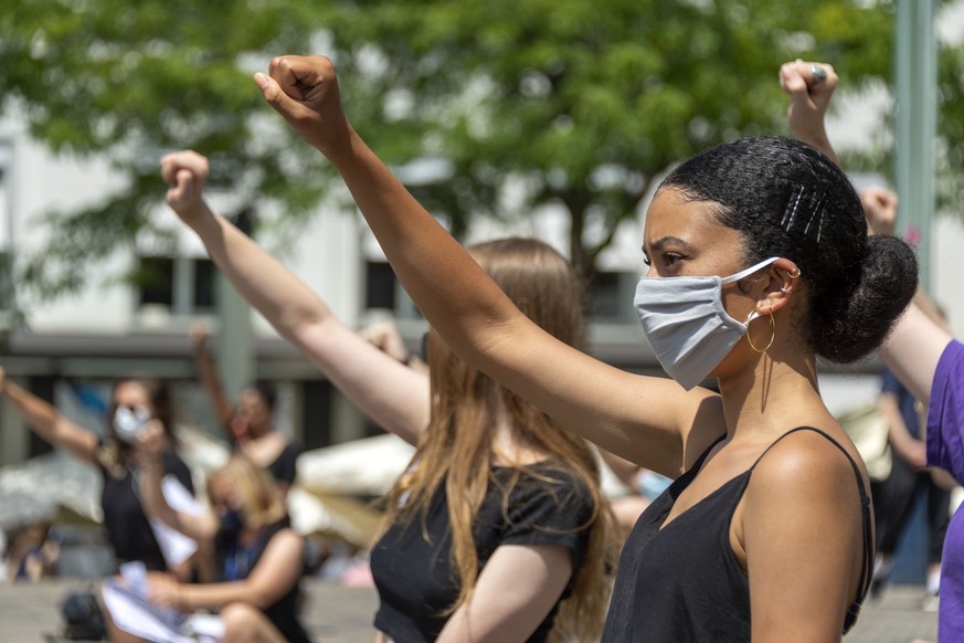 Teilnehmer an einer Platzkundgebung gegen Rassismus, Exit Racism Now!, knien sich mit einer erhobenen Faust auf den Boden auf dem Barfuesserplatz in Basel, am Samstag, 4. Juli 2020. (KEYSTONE/Georgios ...