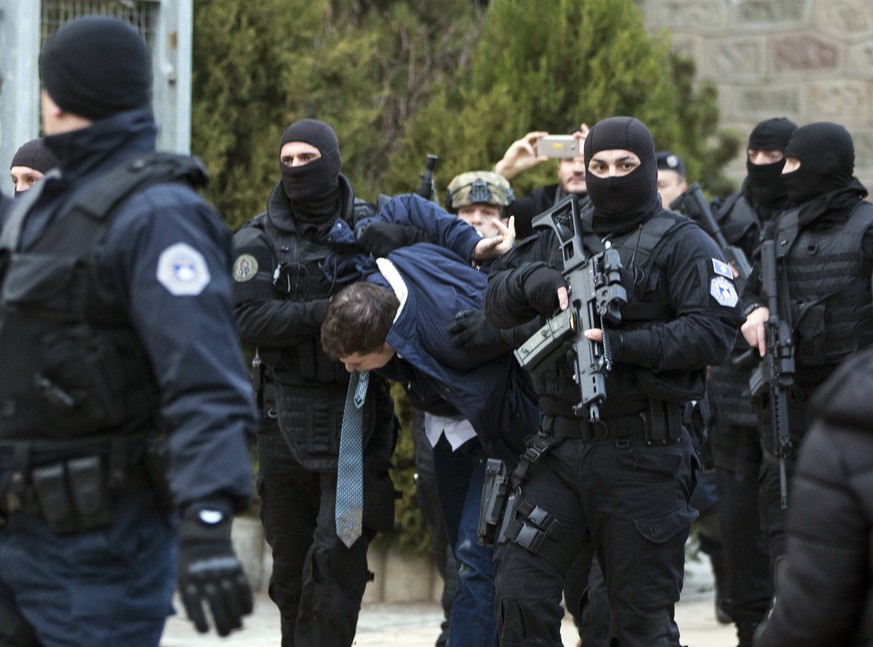 Kosovo police escort Marko Djuric a Serb official to a police station in Kosovo capital Pristina after he was arrested in northern Kosovo town of Mitrovica, Monday, March 26, 2018. Kosovo police arres ...