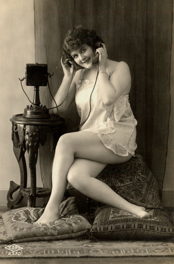 A young woman makes or receives a titillating telephone call in her underwear, circa 1915. (Photo by Vintage Images/Getty Images)