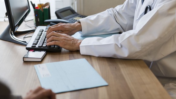 ARCHIV - ZUM ENTSCHEID DES BUNDESRATES ZUR EINFUEHRUNG DES ELEKTRONISCHEN PATIENTENDOSSIERS STELLEN WIR IHNEN FOLGENDES BILDMATERIAL ZUR VERFUEGUNG - [EDITORS NOTE: POSED PICTURE] A doctor holds a con ...
