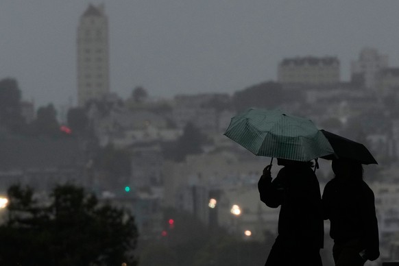 People carry umbrellas while walking on a path at Alamo Square Park, in San Francisco, Tuesday, Dec. 23, 2025. (AP Photo/Jeff Chiu)
Extreme Weather California