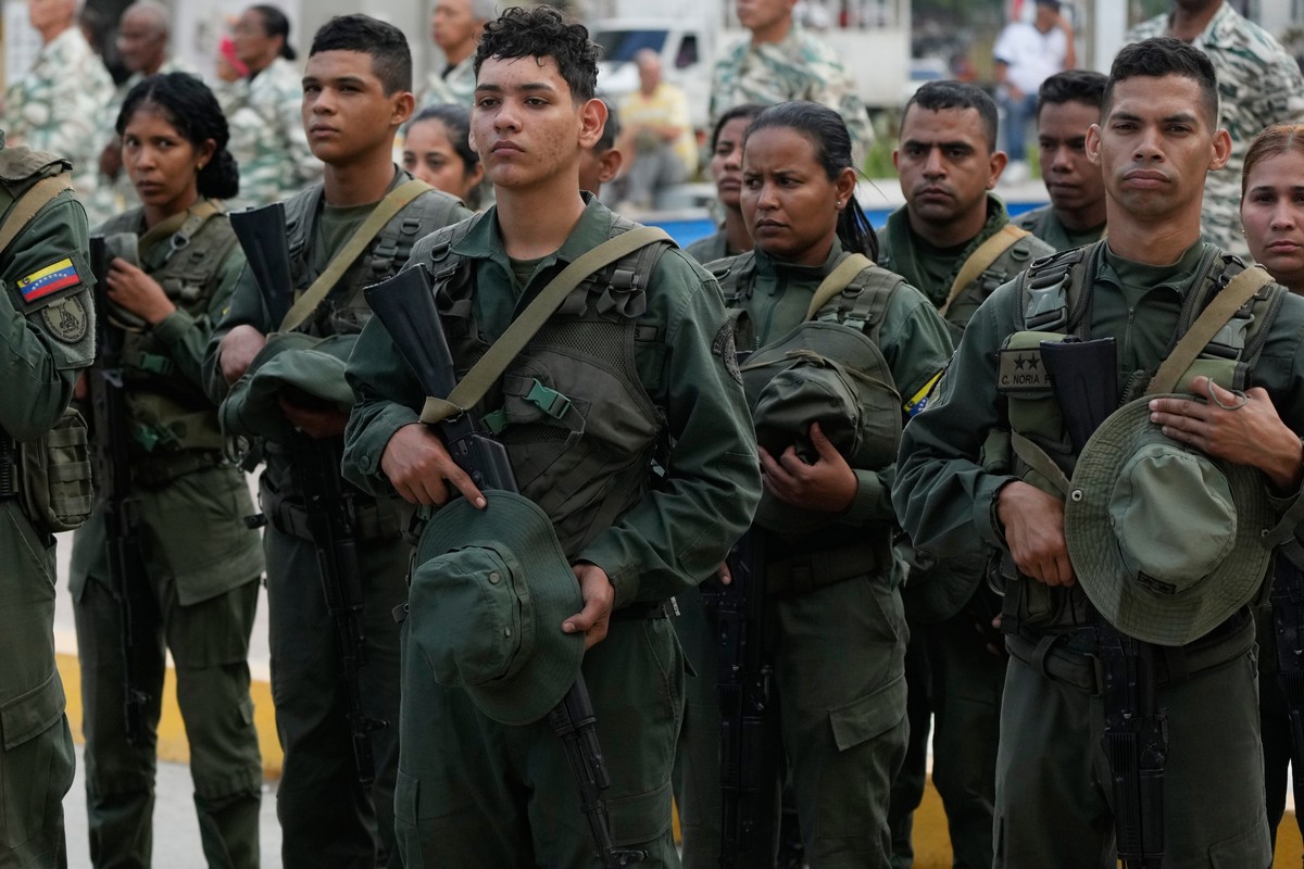 Soldiers remove their caps in honor of fellow soldiers killed in the U.S. capture of Venezuelan President Nicolas Maduro and his wife during the soldiers' funeral in Caracas, Venezuela, Wednesday ...