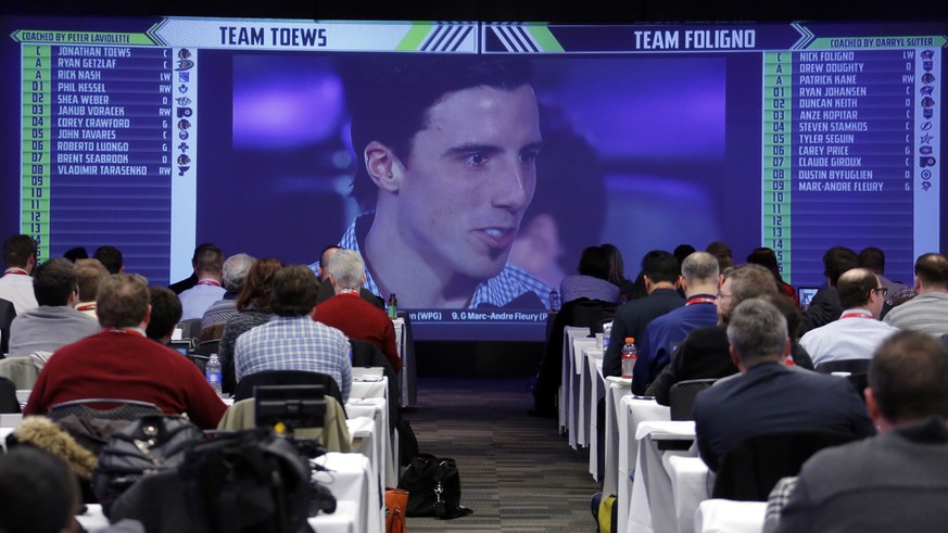 Members of the media watch on a television in a hotel ballroom as Pittsburgh Penguins goalie Marc-Andre Fleury is chosen by Team Toews during the NHL Fantasy Draft in Columbus, Ohio, Friday, Jan. 23, ...