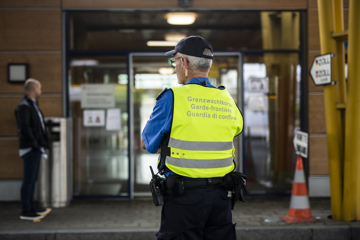 Ein Grenzwaechter am Autobahn-Zoll kontrolliert die Einhaltung des Abstandes von Menschen, die zur Ruckerstaettung der Mehrwertsteuer anstehen, aufgenommen am Montag, 15. Juni 2020, in Kreuzlingen. Di ...