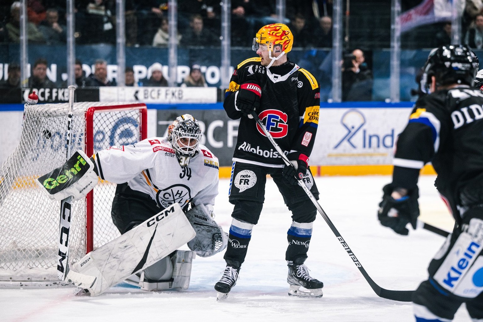 Le top scorer PostFinance fribourgeois Lucas Wallmark, droite, masque le gardien luganais Niklas Schlegel, gauche, lors du but 1-0, lors du 5 eme match du 1/4 de final de playoff du championnat suisse ...