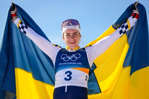 Ebba Andersson, of Sweden, celebrates after winning the gold medal in the cross country skiing women's 50km mass start classic at the 2026 Winter Olympics, in Tesero, Italy, Sunday, Feb. 22, 2026 ...