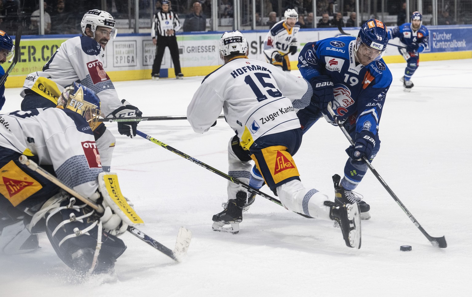 Zugs Torhueter Leonardo Genoni, links, kaempft um den Puck gegen Zuerichs Reto Schaeppi, rechts, im sechsten Eishockey Playoff-Finalspiel der National League zwischen den ZSC Lions und dem EV Zug am F ...