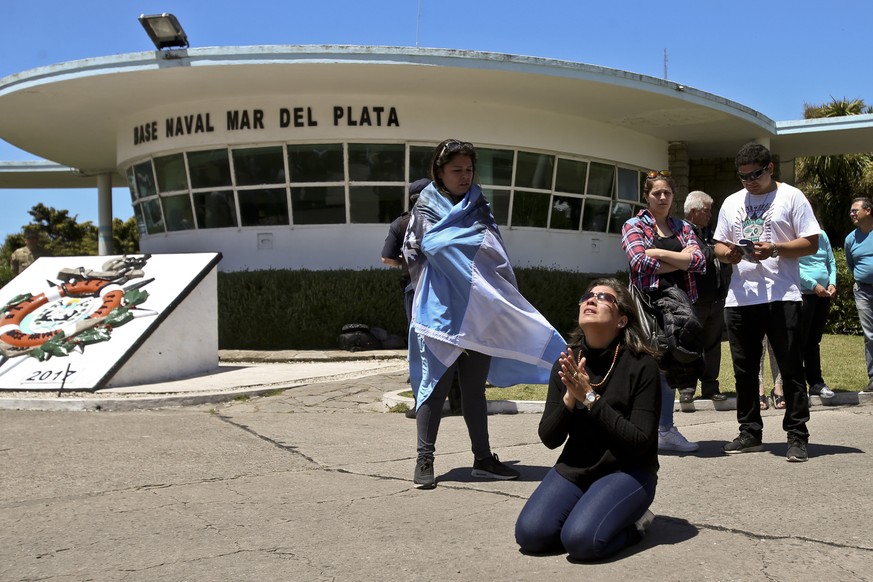 A relative of missing submarine crew member Celso Oscar Vallejo kneels in prayer in front of the Mar de Plata Naval Base, Argentina, Saturday, Nov. 25, 2017. The international search continues for the ...