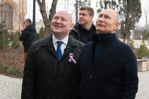 epa10530937 A handout photo made available by the Russian Presidential Press Office shows Russian President Vladimir Putin (R) and Sevastopol Governor Mikhail Razvozhayev (L) visit a children&#039;s a ...