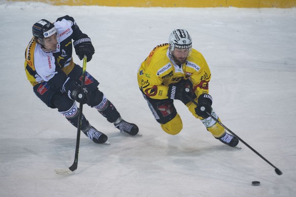 Ambri&#039;s player Cedric H�chler, left, fight for the puck with Bern&#039;s player Tristan Scherwey, right, during the preliminary round game of National League A (NLA) Swiss Championship 2020/21 be ...
