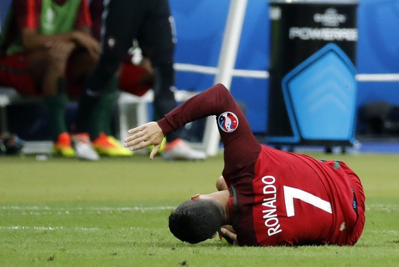 epa05419077 Cristiano Ronaldo of Portugal reacts on the pitch after a tackle during the UEFA EURO 2016 Final match between Portugal and France at Stade de France in Saint-Denis, France, 10 July 2016.  ...