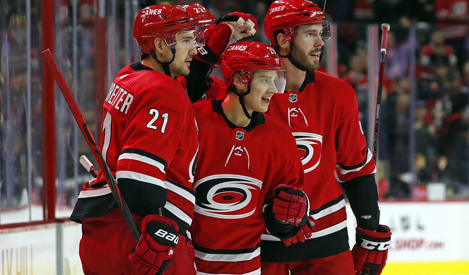 Carolina Hurricanes&#039; Sebastian Aho (20) celebrates his goal against the Minnesota Wild with teammates Nino Niederreiter (21) and Joel Edmundson, right, during the second period of an NHL hockey g ...