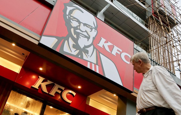 epa04813992 A man walks pass in front of the KFC first branch restaurant in Yangon, Myanmar, 22 June 2015. KFC, US based Yum Brands, is preparing to open it&#039;s first restaurant in Yangon on 30 Jun ...