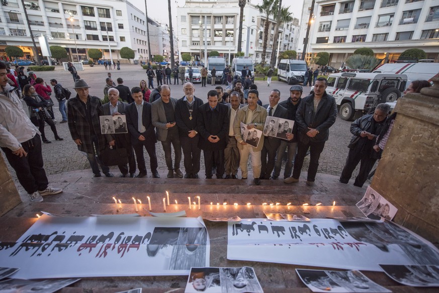 epa07249596 Cristobal Lopez Romero Archbishop of Rabat and People hold and photos depicting the murdered Scandinavian tourists as they gather to pay tribute to the victims, in front the St. Peter&#039 ...