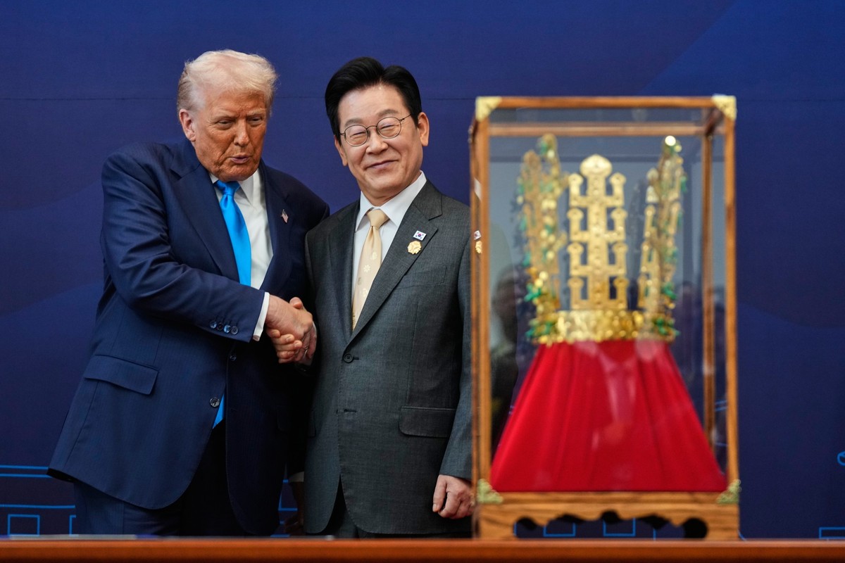 President Donald Trump shakes hands with South Korean President Lee Jae Myung as he receives a gift of a gold crown and an award of the Grand Order of Mugunghwa, not seen, during a high honor ceremony ...