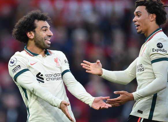 epa09543905 Liverpool's Mohamed Salah (L) celebrates with Trent Alexander-Arnold (R) after scoring the 0-3 goal during the English Premier League soccer match between Manchester United and Liverpool F ...