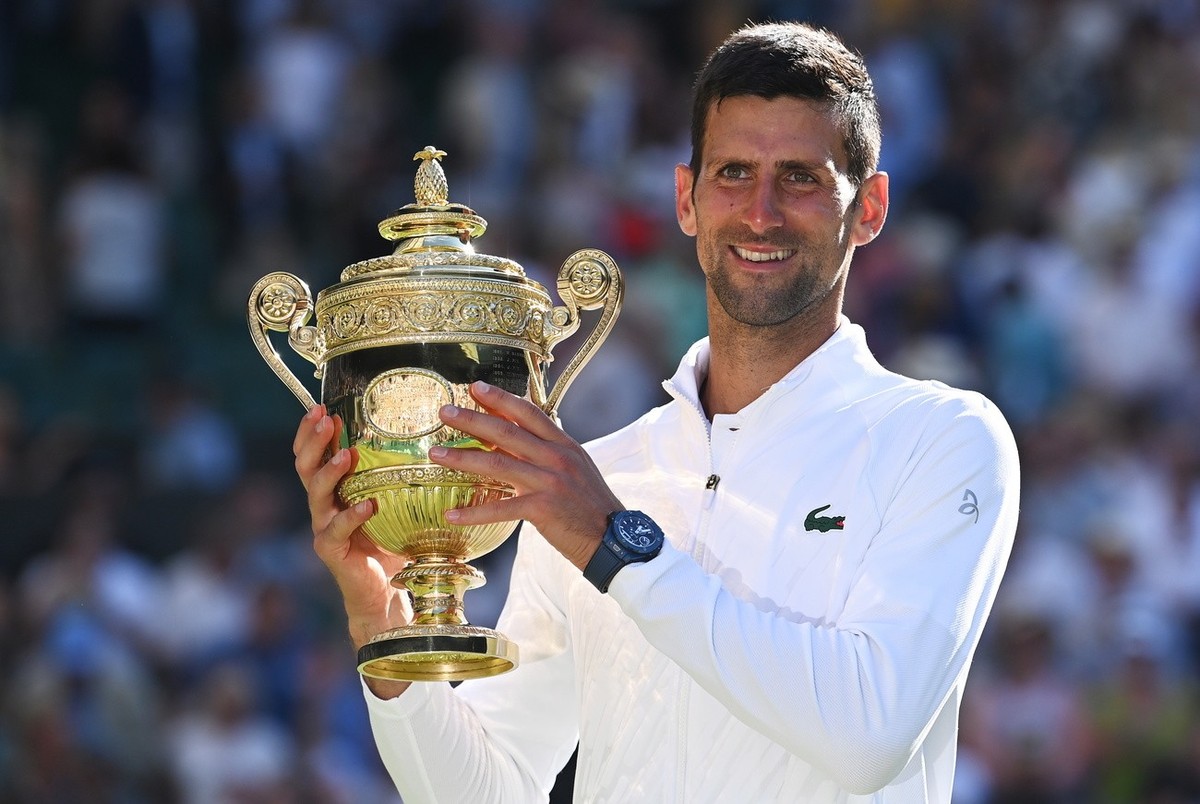 epa10064041 Novak Djokovic of Serbia poses with the trophy after winning the men's final match against Nick Kyrgios of Australia at the Wimbledon Championships, in Wimbledon, Britain, 10 July 202 ...