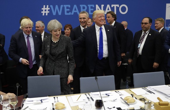 FILE - In this Thursday, May 25, 2017 file photo U.S. President Donald Trump touches the back of British Prime Minister Theresa May during a working dinner meeting at the NATO headquarters during a NA ...