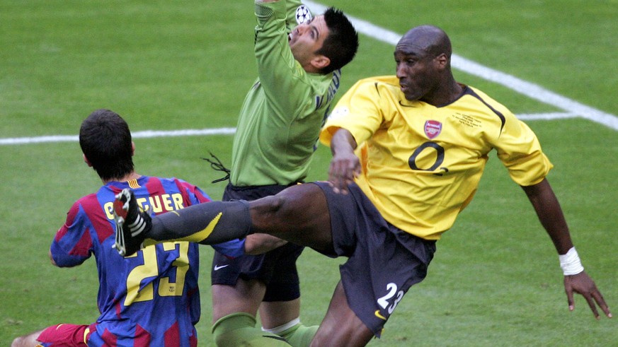 Sol Campbell of Arsenal, right, challenges with Barcelona goalkeeper Victor Valdes, center, during their Champions League final soccer match in the Stade de France in Saint-Denis, outside Paris, Wedne ...