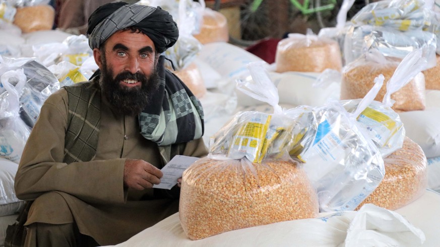 epa09900391 Afghans line up to receive ration aid distributed by World Food Program (WFP) during the fasting month of Ramadan, in Kandahar, Afghanistan, 21 April 2022. Muslims around the world celebra ...