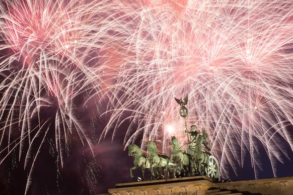 epa06411828 Fireworks explode behind the Quadriga statue of the Brandenburg Gate shortly after midnight in Berlin, Germany, 01 January 2018. Hundreds of thousands of revelers gather in the city center ...