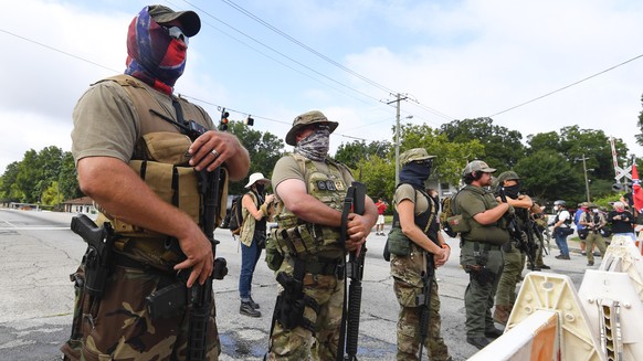 epa08605937 Far-right groups, including militias and white supremacists, demonstrate on Main Street during a rally in Stone Mountain, Georgia, USA, 15 August 2020. The rally was suppopsed to be held a ...