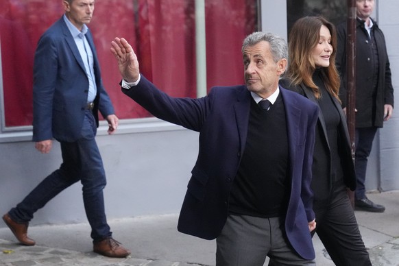 Former French President Nicolas Sarkozy and his wife Carla Bruni-Sarkozy leave their home Tuesday, Oct. 21, 2025 in Paris as Nicolas Sarkozy heads to prison to serve time for a criminal conspiracy to  ...