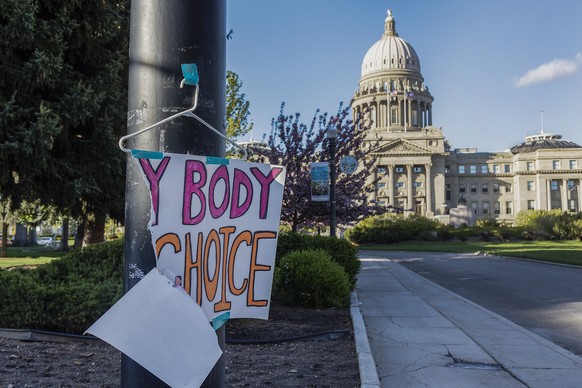 FILE - A sign reading &quot;My body, my choice,&quot; is taped to a hanger taped to a streetlight in front of the Idaho state Capitol Building in Boise, Idaho, May 3, 2022. Abortion is banned in Idaho ...