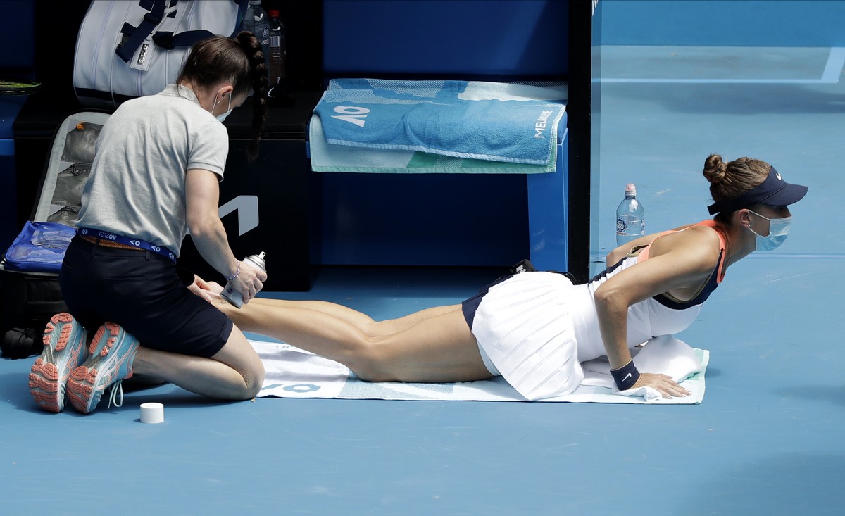 Switzerland's Belinda Bencic receives treatment to a foot injury during her second round match against Russia's Svetlana Kuznetsova at the Australian Open tennis championship in Melbourne, A ...