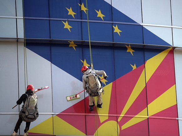 Arbeiter putzen die Fassade am EU-Büro in Skopje: Aufgemalt sind die Flaggen der EU und Nordmazedoniens.