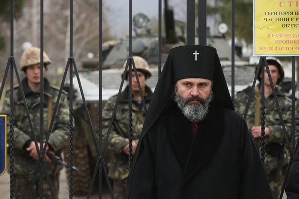 Ein orthodoxer Geistlicher steht am 2. März vor dem Tor zur ukrainischen Militärbasis auf der Krim.