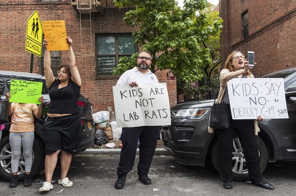 epa09248143 A small group of people against giving the COVID-19 vaccination to children gather across the street from a vaccination site outside of the Bronx Writing Academy in the Bronx borough of Ne ...