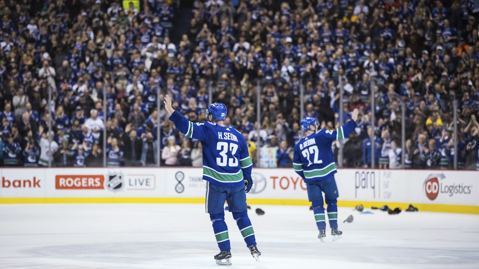 Vancouver Canucks&#039; Henrik Sedin, left, and his twin brother, Daniel Sedin, wave to the crowd after the Canucks defeated the Arizona Coyotes 4-3 in the brothers&#039; last home NHL hockey game, Th ...