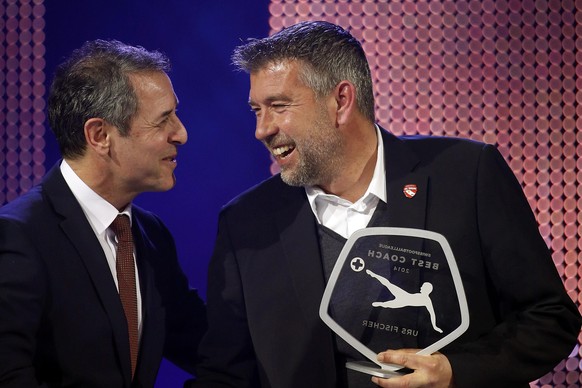 Fischer (rechts) bekommt die Trophäe vom österreichischen Nati-Coach Marcel Koller überreicht.