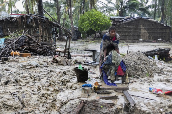 epaselect epa10521047 A woman repairs some clothes after the destruction caused by storm Freddy in Quelimane, Mozambique, March 13, 2023. This is one of the longest lasting storms on record, after ...