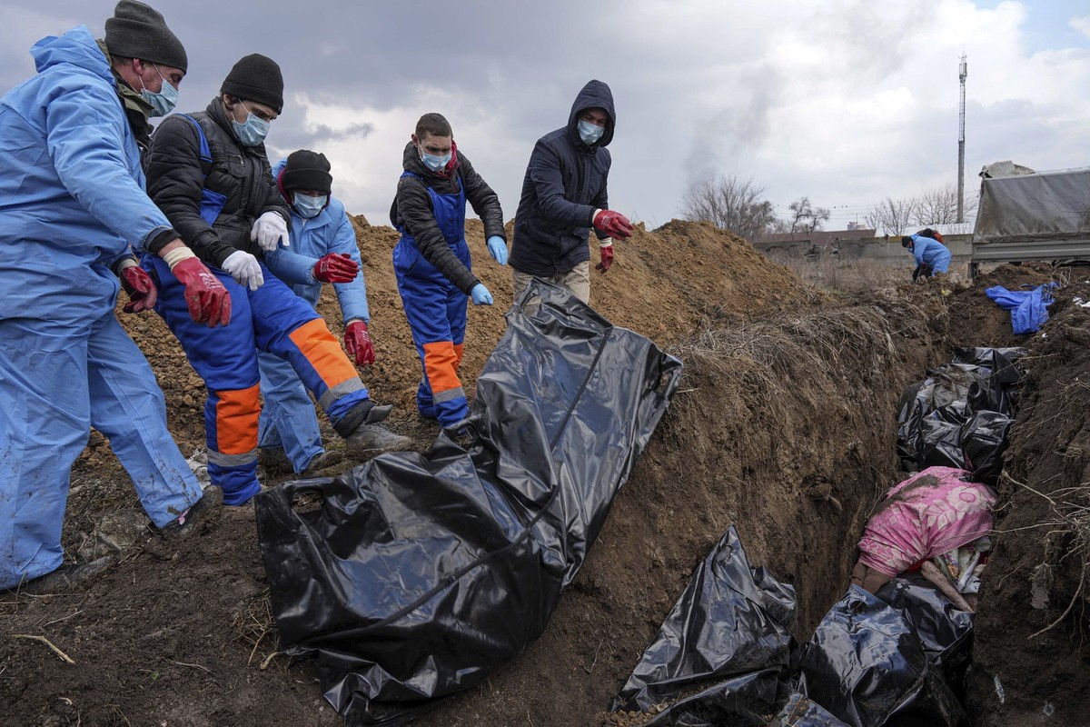 FILE - Dead bodies are placed into a mass grave on the outskirts of Mariupol, Ukraine, March 9, 2022, as people cannot bury their dead because of the heavy shelling by Russian forces. The GOP has been ...