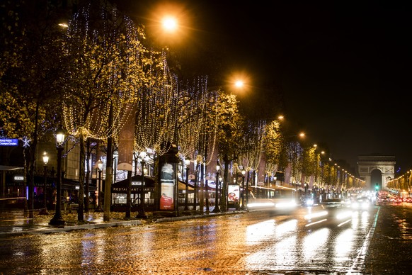 epa06354605 Christmas lights hang from the trees during a rainy night on the Champs Elysees avenue in Paris, France, 27 November 2017. EPA/ETIENNE LAURENT