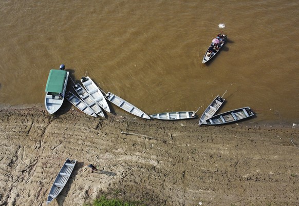 People arrive by boat to vote during a presidential run-off election pitting President Jair Bolsonaro against former President Luiz Inacio Lula da Silva, in Autazes, Amazonas State, Brazil, Sunday, Oc ...