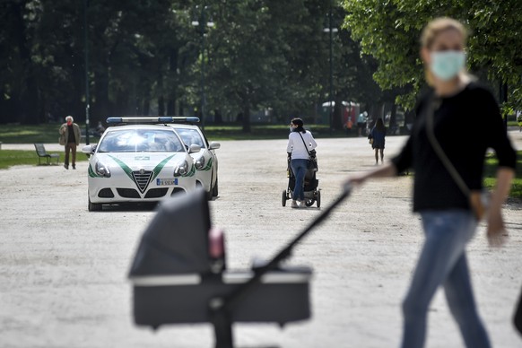 Local Police patrols a park that was closed during the lockdown due to the coronavirus outbreak, as mothers and babies made their appearance after reopening in Milan, Italy, Wednesday, May 6, 2020. (C ...