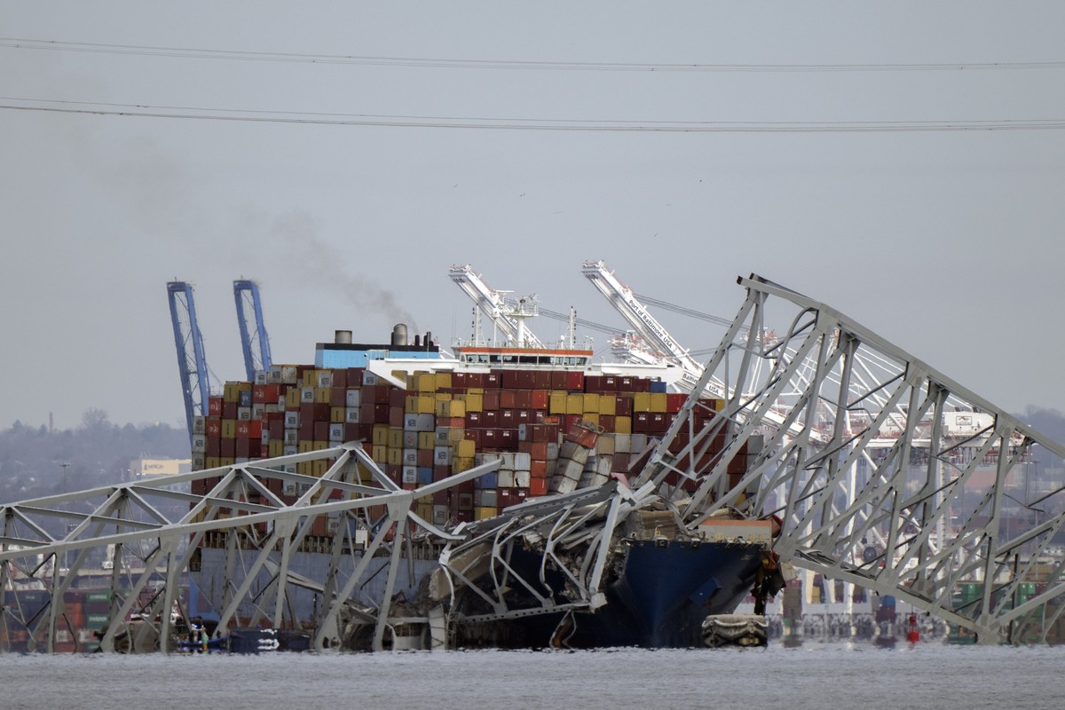 A container ship rests against wreckage of the Francis Scott Key Bridge on Tuesday, March 26, 2024, as seen from Pasadena, Md. The ship rammed into the major bridge in Baltimore early Tuesday, causing ...