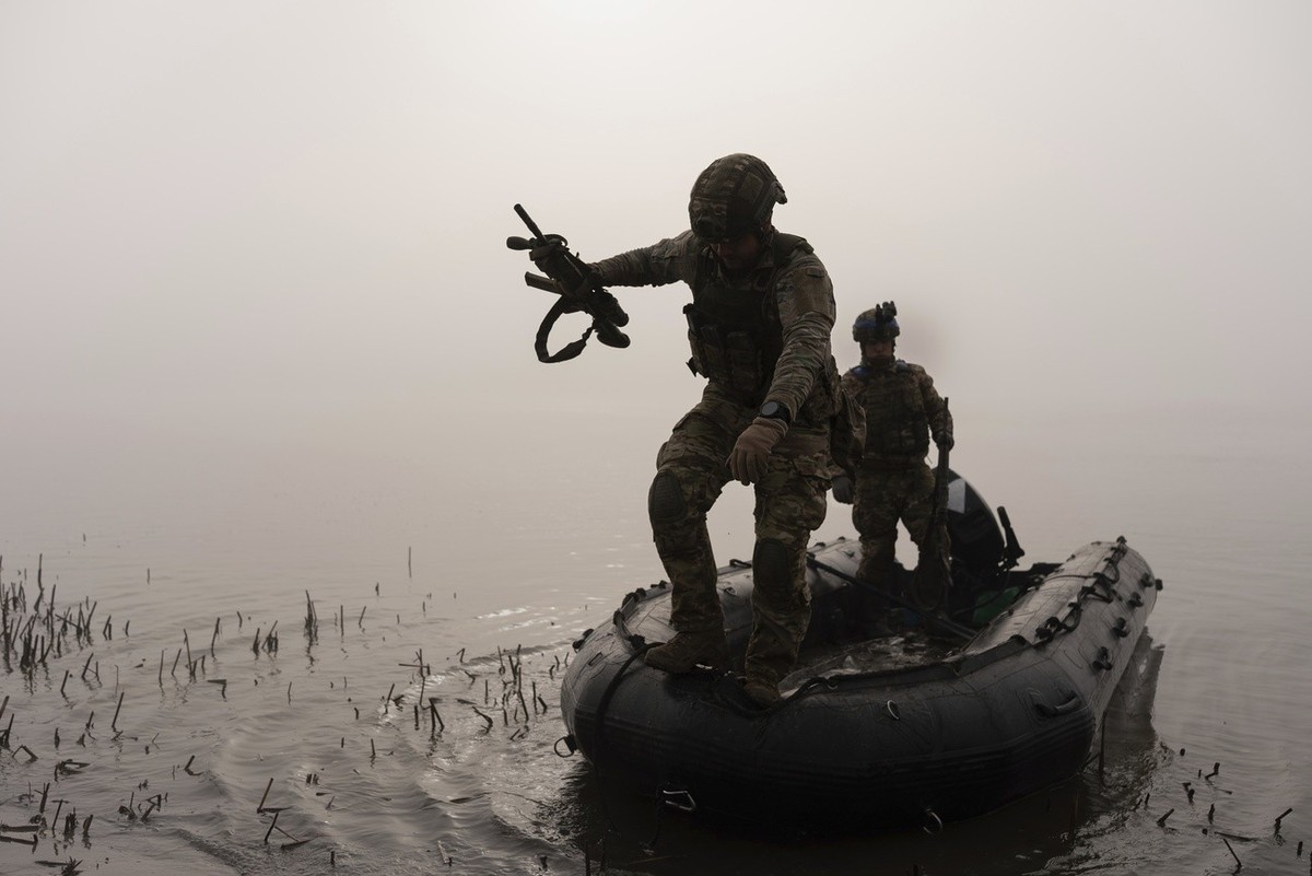 A Ukrainian serviceman jumps out of the boat onto the shore of Dnipro at the frontline near Kherson, Ukraine, Sunday, Oct. 15, 2023. (AP Photo/Alex Babenko)