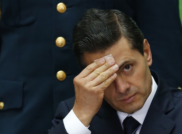 FILE - In this Sept. 7, 2017 file photo, Mexico&#039;s President Enrique Pena Nieto wipes sweat from his forehead during the International Financial Inclusion Forum at the National Palace in Mexico Ci ...