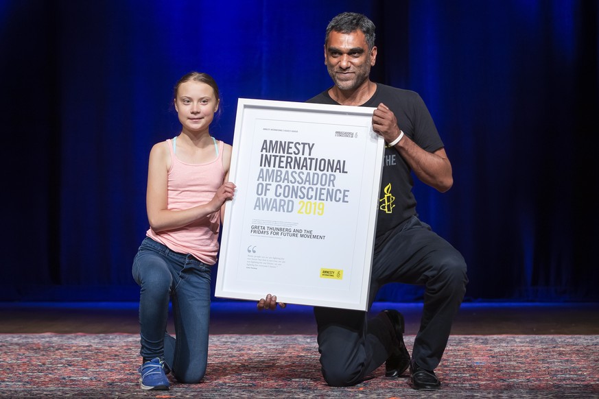 epa07847615 Swedish climate activist Greta Thunberg (L) poses with Amnesty International Secretary General Kumi Naidoo (R) after Thunberg was awarded Amnesty International&#039;s Ambassador of Conscie ...