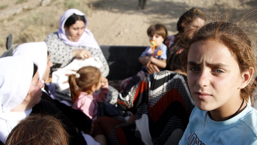 epa04358935 A picture made avaliable on 18 August 2014 of Yazidi refugees sit in a truck awaiting transfer as they flee from Iraq near Sirnak city, at the Turkish-Iraqi border, 17 August 2014. Islamic ...