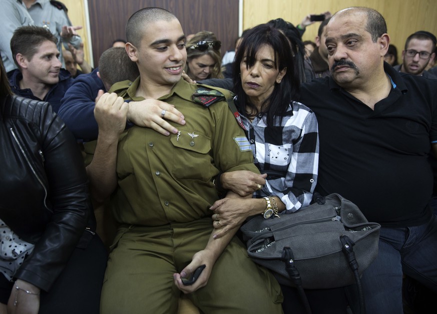 Israeli solider Sgt. Elor Azaria waits with his parents for the verdict inside the military court in Tel Aviv, Israel on Wednesday, Jan. 4, 2017. An Israeli military court is set to deliver the verdic ...