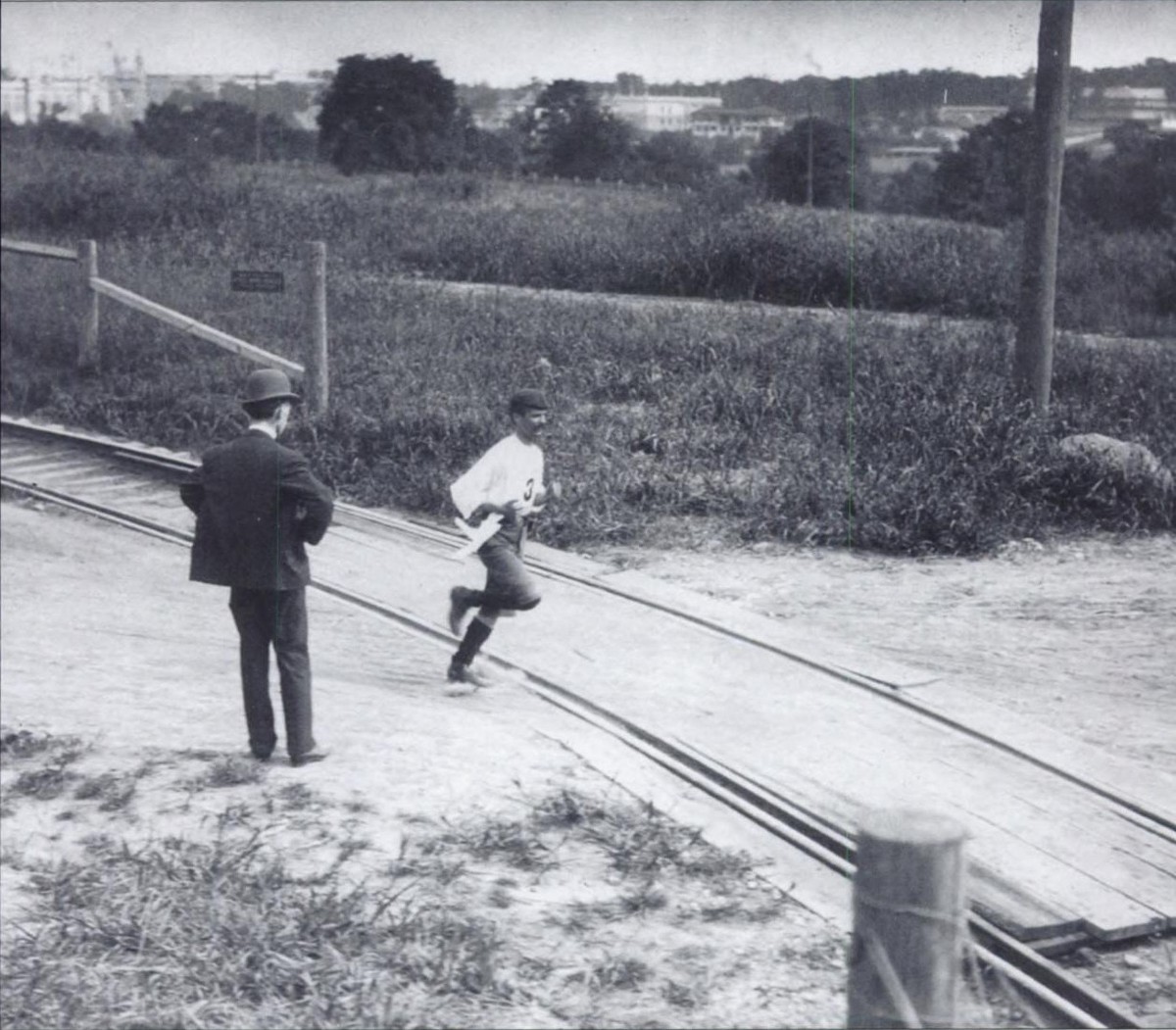 Le Cubain court sur une route poussiéreuse traversée par des voies de chemin de fer.