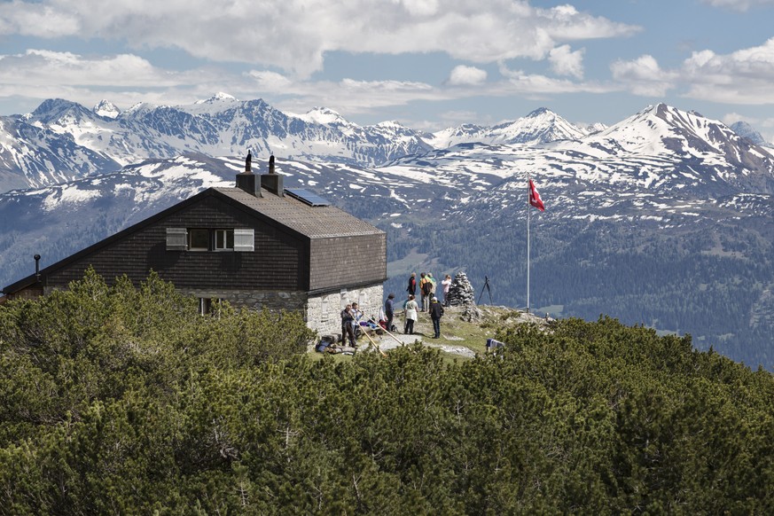 Bergwanderer geniessen den herrlichen Bergfruehlingstag zu den Alphornklaengen der Geschwister Frieda und Peter Bislin vor der Ringelspitzhuette des SAC auf 2000 Meter ueber Meer mit der Kulisse der v ...